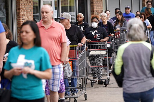 People wait for an H-E-B grocery store to open Tuesday, March 17, 2020, in Spring, Texas. Grocery store executives and city officials reassured the community, on Monday, that plenty of food will be available in their stores and urged people not to stockpile groceries amid coronavirus concerns. (AP Photo/David J. Phillip)