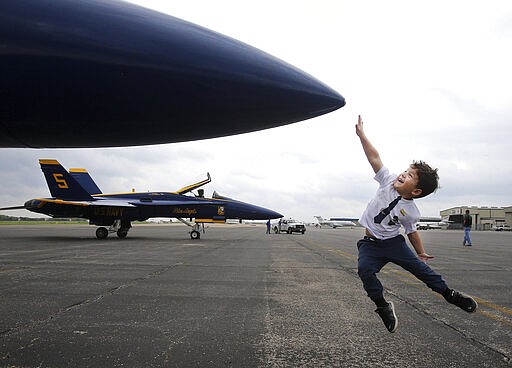 Micha Robbins, 4, tries to touch the nose cone of a F/A-18 Hornet Blue Angel as the Navy's Demonstration team landed Wednesday, March 18, 2020, in Waco, Texas to refuel. (Jerry Larson/Waco Tribune-Herald via AP)