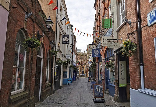 A view of an empty street in Exeter, southwest England, Saturday March 21, 2020 a day after the British government ordered the closure of all bars, restaurants, movie theaters and other places where people congregate in an attempt to halt the spread of the coronavirus. For some people the COVID-19 coronavirus causes mild or moderate symptoms, but for others it causes severe illness. (AP Photo/Derl McCrudden)