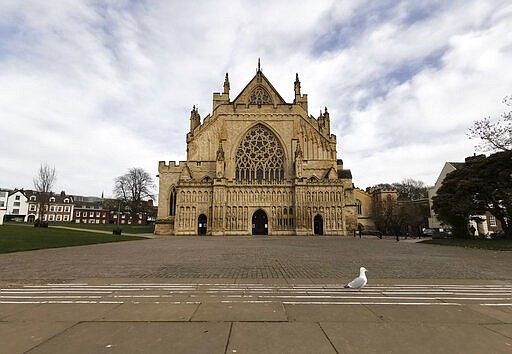 Exeter Cathedral stands deserted apart from a lone seagull, in Exeter, southwest England, Saturday March 21, 2020 a day after the British government ordered the closure of all bars, restaurants, movie theaters and other places where people congregate in an attempt to halt the spread of the coronavirus. For some people the COVID-19 coronavirus causes mild or moderate symptoms, but for others it causes severe illness. (AP Photo/Derl McCrudden)