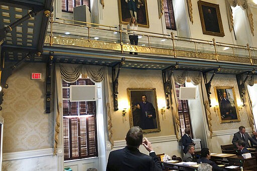 FILE - In this Thursday, March 19, 2020 file photo, Republican Rep. William Herbkersman, R-Bluffton speaks to Rep. Beth Bernstein, D-Columbia as she practices &quot;social distancing&quot; in the South Carolina House in Columbia, S.C. The House returned briefly to approve $45 million in emergency funds for state health officials to fight the COVID-19 coronavirus. (AP Photo/Jeffrey Collins)