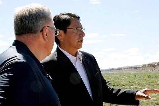 FILE - In this May 28, 2019, file photo, Navajo Nation President Jonathan Nez, right, and U.S. Interior Secretary David Bernhardt look out over Pueblo Bonito, at Chaco Culture National Historical Park, N.M. In the U.S. Southwest, Nez, the leader of the Navajo Nation restricted travel for employees who answer to him and wrote letters to federal officials saying anyone pulled away from duty at federal health care facilities on the vast reservation wouldn't be welcome back for 45 days. (Hannah Grover/The Daily Times via AP, File)