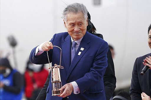 Tokyo 2020 Olympics chief Yoshiro Mori carries the Olympic flame during the Flame Arrival Ceremony at Japan Air Self-Defense Force Matsushima Base in Higashimatsushima in Miyagi Prefecture, north of Tokyo, Friday, March 20, 2020. The Olympic flame from Greece arrived in Japan even as the opening of the the Tokyo Games in four months is in doubt with more voices suggesting the games should to be postponed or canceled because of the worldwide virus pandemic. (AP Photo/Eugene Hoshiko)