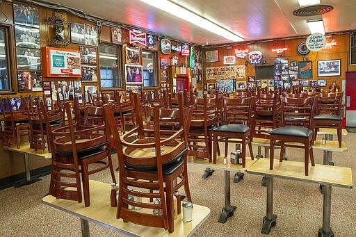 In this March 19, 2020 photo, chairs are stacked on the tables of Katz's Delicatessen on the Lower East Side of New York. The iconic eatery isonlyn open for take out and delivery orders due to the coronavirus outbreak. (AP Photo/Mary Altaffer)