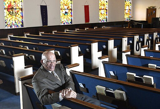 The Rev. Alvin J. Gwynn Sr., of Friendship Baptist Church in Baltimore, sits in his church's sanctuary, Thursday, March 19, 2020. He bucked the cancellation trend by holding services the previous Sunday. But attendance was down by about 50%, and Gwynn said the day&#146;s offering netted about $5,000 compared to a normal intake of about $15,000. &#147;It cuts into our ministry,&#148; he said. &#147;If this keeps up, we can&#146;t fund all our outreach to help other people.&#148; (AP Photo/Steve Ruark)