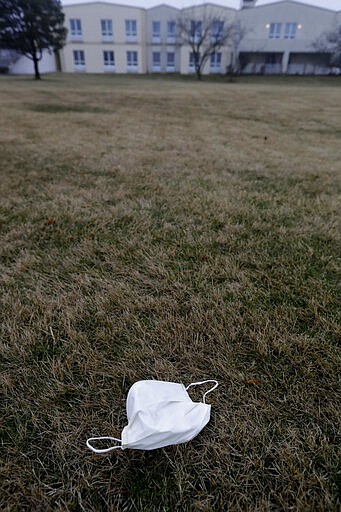 FILE - In this March 19, 2020, file photo, a face mask lies on the ground outside the Chateau Nursing and Rehabilitation Center in Willowbrook, Ill. Burgeoning coronavirus outbreaks at this and other nursing homes in Washington, New Jersey and elsewhere are laying bare the risks of the industry&#146;s long-running problems, including a struggle to control infections and a staffing crisis that relies on poorly paid aides who can't afford to stay home sick. (AP Photo/Nam Y. Huh, File)