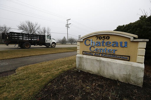 A truck passes the Chateau Nursing and Rehabilitation Center entrance sign in front of the facility in Willowbrook, Ill., Thursday, March 19, 2020. The number of COVID-19 cases inside a nursing home in west suburban Willowbrook has increased.  Dr. Ngozi Ezike, director of the Illinois Department of Public Health, said staff at the nursing home and at similar facilities statewide are being screened before they start work to prevent further spread of the virus to vulnerable residents. (AP Photo/Nam Y. Huh)