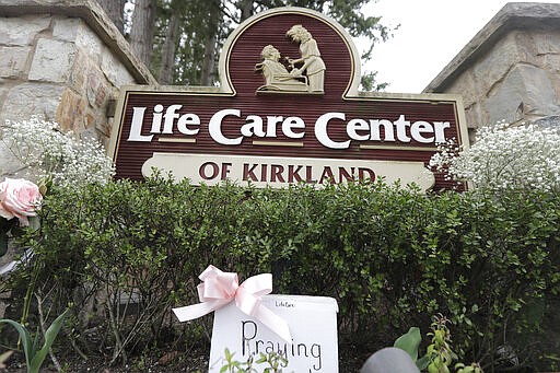 A sign that reads &quot;Praying For You&quot; is shown at the base of the entrance sign for the at the Life Care Center in Kirkland, Wash., Tuesday, March 10, 2020, near Seattle. The nursing home is at the center of the outbreak of the COVID-19 coronavirus in Washington state. (AP Photo/Ted S. Warren)
