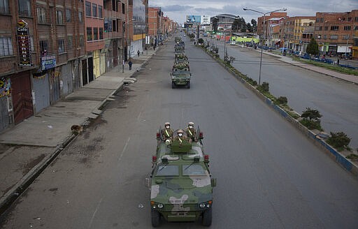 Military armored vehicles patrol the streets during a quarantine in El Alto, Bolivia, Friday, March 20, 2020. Authorities have decreed a quarantine from 5pm to 5am in an attempt to stop the spread of the new coronavirus. The vast majority of people recover from the COVID-19 disease. (AP Photo/Juan Karita)