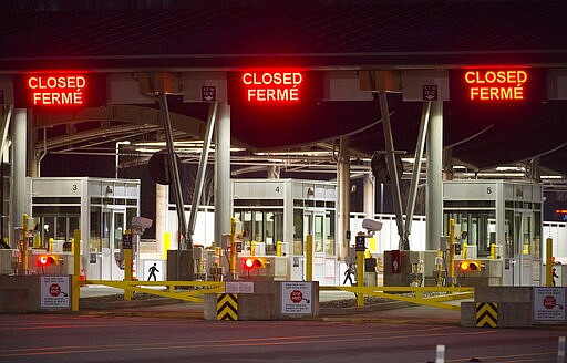 The Canadian border is pictured at the Peace Arch Canada-U.S. border crossing in Surrey, British Columbia, Friday, March 20, 2020. New restrictions in effect at midnight Friday along Canada's shared border with the United States because of the coronavirus focus more on blocking tourists and bargain-hunters than on clearing the way for so-called &quot;essential&quot; travel such as truckers hauling freight, health professionals and others who live on one side and work on the other. (Jonathan Hayward/The Canadian Press via AP)