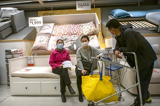 People wear face masks to protect against coronavirus infection as they shop at an IKEA store in Beijing, Saturday, March 21, 2020. Three major American states are locking down their residents in the face of a rapidly advancing virus storm that is already severely straining health systems in parts of Europe. The virus causes only mild or moderate symptoms, such as fever and cough, for most people, but severe illness is more likely in the elderly and people with existing health problems. (AP Photo/Mark Schiefelbein)