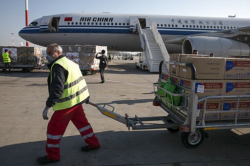 Personnel of the Eleftherios Venizelos International Airport unload boxes with medical supplies, in Athens, Saturday, March 21, 2020. China has sent medical supplies to Greece, including hundreds of thousands of surgical and protection masks. For most people, the new coronavirus causes only mild or moderate symptoms. For some it can cause more severe illness. (AP Photo/Yorgos Karahalis)