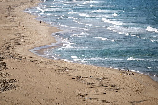 People run along the Ramlet al-Baida public beach, which is almost empty of residents and tourists in Beirut, Lebanon, Saturday, March 21, 2020. For most people, the new coronavirus causes only mild or moderate symptoms, such as fever and cough. For some, especially older adults and people with existing health problems, it can cause more severe illness, including pneumonia. (AP Photo/Hassan Ammar)