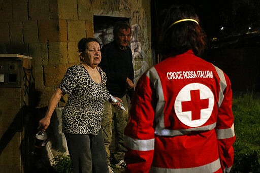 Red Cross volunteers bring food and disinfectants to homeless at Verano cemetery in Rome Saturday, March 21, 2020. For most people, the new coronavirus causes only mild or moderate symptoms. For some it can cause more severe illness. (Cecilia Fabiano/LaPresse via AP)