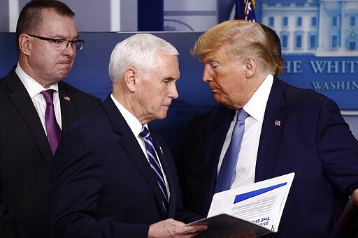 Vice President Mike Pence walks to the podium as President Donald Trump looks on during a coronavirus task force briefing at the White House, Saturday, March 21, 2020, in Washington. (AP Photo/Patrick Semansky)