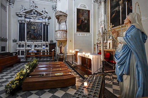 Coffins wait to be transported to cemetery, in the church of Serina, near Bergamo, Northern Italy, Saturday, March 21, 2020. Italy&#146;s tally of coronavirus cases and deaths keeps rising, with new day-to-day highs: 793 dead and 6,557 new cases. For most people, the new coronavirus causes only mild or moderate symptoms. For some it can cause more severe illness. (Claudio Furlan/LaPresse via AP)