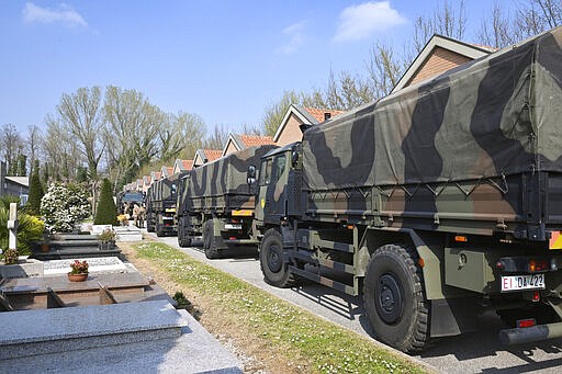 A convoy of Italian Army trucks arrives from Bergamo carrying bodies of coronavirus victims to the cemetery of Ferrara, Italy, where they will be cremated, Saturday, March 21, 2020. The transfer was made necessary since Bergamo mortuary reached maximum capacity. For most people, the new coronavirus causes only mild or moderate symptoms. For some it can cause more severe illness, especially in older adults and people with existing health problems. (Massimo Paolone/LaPresse via AP)