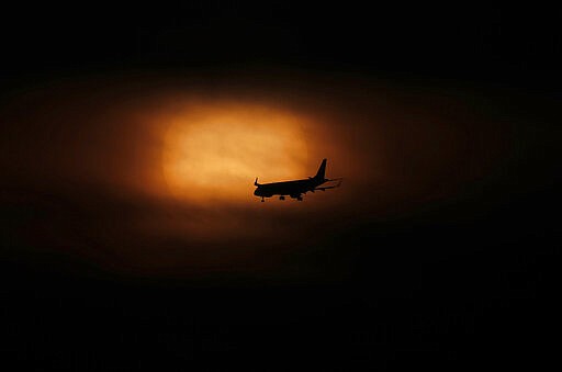 An airplane comes in for its landing as the sun rises in Mexico City, Saturday, March 21, 2020. Many countries in Latin America have taken aggressive measures to deal with the new coronavirus such as closing their borders, dock and airports to foreigners. Mexico, by contrast, has so far taken a &#147;business as usual&#148; attitude. (AP Photo/Marco Ugarte)