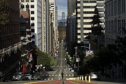 A man stands in the middle of a cable car tracks on a near empty California Street in San Francisco, Saturday, March 21, 2020. Some 40 million Californians are coping with their first weekend under a statewide order requiring them to stay at home to help curb the spread of the coronavirus(AP Photo/Jeff Chiu)