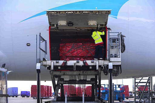 In this photo released by Xinhua News Agency, a worker handles medical supplies mobilized by Chinese charities that are heading to France to help combat the coronavirus,   at Liege airport, Wednesday, March 18, 2020, in Liege, Belgium. Desperate travelers choked European border crossings Wednesday after countries implemented strict controls to try to slow the spread of the coronavirus, which has now infected more than 200,000 people worldwide and killed more than 8,000. The virus causes only mild or moderate symptoms, such as fever and cough, for most people, but severe illness is more likely in the elderly and people with existing health problems. (Zheng Huansong/Xinhua via AP)