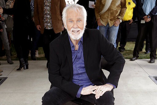 FILE - In this Oct. 24, 2017 file photo, Kenny Rogers poses with his star on the Music City Walk of Fame in Nashville, Tenn. Actor-singer Kenny Rogers, the smooth, Grammy-winning balladeer who spanned jazz, folk, country and pop with such hits as &#147;Lucille,&#148; &#147;Lady&#148; and &#147;Islands in the Stream&#148; and embraced his persona as &#147;The Gambler&#148; on record and on TV died Friday night, March 20, 2020. He was 81. (AP Photo/Mark Humphrey, File)