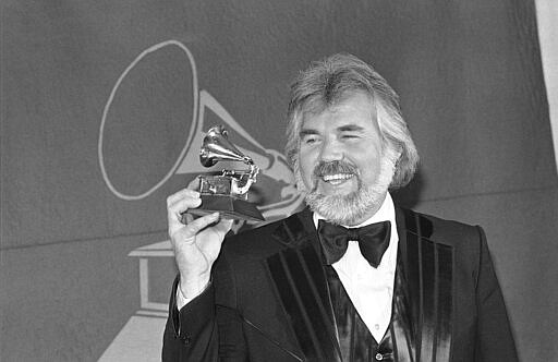 FILE- In this Feb. 28, 1980 file photo, Kenny Rogers holds a Grammy Award he received during presentation in Los Angles.  Rogers, who embodied &#147;The Gambler&#148; persona and whose musical career spanned jazz, folk, country and pop, has died at 81. A representative says Rogers died at home in Georgia on Friday, March 20, 2020. (AP Photo/McLendon, File)