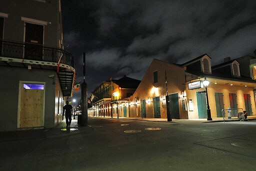 FILE - In this Thursday, March 19, 2020, file photo, a view of the nearly deserted Bourbon Street, which is normally bustling with tourists and revelers, is seen in the French Quarter of New Orleans. The old saying &#147;Let the good times roll&#148; has given way here to a new municipal maxim: &#147;Wash your hands.&#148; A month ago the city was awash in people and steeped in its annual tradition of communal joy &#151; the Mardi Gras season. But now New Orleans has joined those places shutting down bars, eliminating restaurant dining and banning crowds. (AP Photo/Gerald Herbert, File)