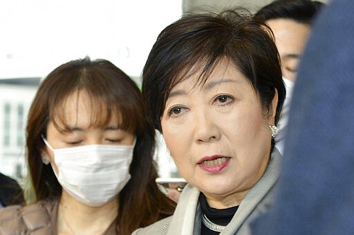 Tokyo Gov. Yuriko Koike, right, answers a reporter's question about the latest policy of International Olympic Committee, at Tokyo Metropolitan Government in Tokyo Monday, March 23, 2020. The IOC will take four weeks to weigh options for the Tokyo Games amid mounting calls from athletes and Olympic officials for a postponement due to the coronavirus pandemic. (Kyodo News via AP)