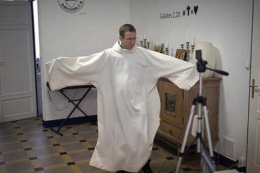 Priest Philippe Rochas prepares for a closed door Sunday mass livestream at the St. Vincent de Paul church in Marseille, southern France, Sunday, March 22, 2020. As mass gatherings are forbidden due to measures to prevent the spread of COVID- 19, priests are using technology to reach worshippers forced to stay at home. For most people, the new coronavirus causes only mild or moderate symptoms. (AP Photo/Daniel Cole)