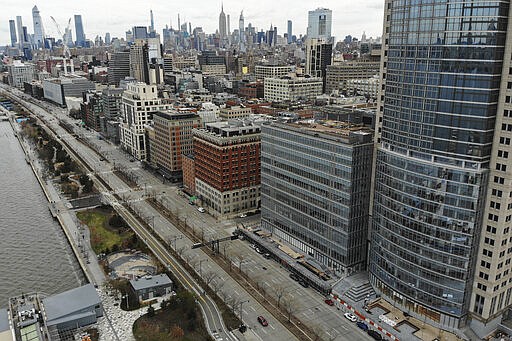 A single vehicle heads downtown along the west side highway as COVID-19 concerns empties a typically busy thoroughfare, Saturday, March 21, 2020, in New York. New York Gov. Andrew Cuomo announced sweeping orders Friday that will severely restrict gatherings of any size for the state's more than 19 million residents and will require workers in nonessential businesses to stay home. (AP Photo/John Minchillo)