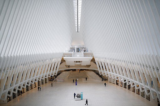 A security guard walks through a sparsely populated transit hub in the downtown financial district as retail stores remain shuttered due to COVID-19 concerns, Saturday, March 21, 2020, in New York. As of Sunday, nearly 2,000 people with the virus have been hospitalized in the state of New York and 114 have died, officials said. More than 15,000 have tested positive statewide, including 9,000 in New York City. (AP Photo/John Minchillo)