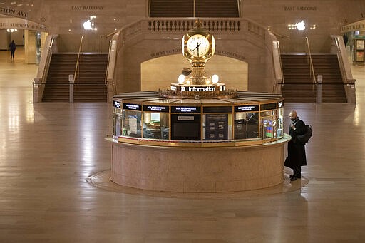 A traveler stands at the information desk at Grand Central Terminal, Tuesday, March 17, 2020, in New York. As of Sunday, nearly 2,000 people with the virus have been hospitalized in the state of New York and 114 have died, officials said. More than 15,000 have tested positive statewide, including 9,000 in New York City.  (AP Photo/Mary Altaffer)