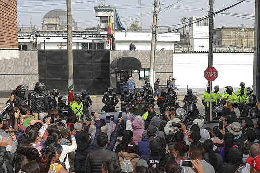 Relatives of inmates gather outside La Modelo jail in Bogota, Colombia, Sunday, March 22, 2020. Violence broke out in the prison out of inmates' fears that authorities are not doing enough to prevent coronavirus inside prisons. (AP Photo/Ivan Valencia)