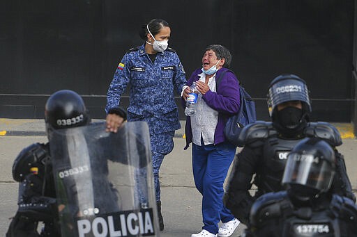 The relative of an inmate cries outside La Modelo jail in Bogota, Colombia, Sunday, March 22, 2020. Violence broke out in the prison out of inmates' fears that authorities are not doing enough to prevent coronavirus inside overcrowded prisons. (AP Photo/Ivan Valencia)