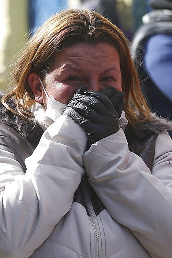 The relative of an inmate cries outside La Modelo jail in Bogota, Colombia, Sunday, March 22, 2020. Violence broke out in the prison out of inmates' fears that prison guards are not doing enough to prevent coronavirus inside overcrowded prisons. (AP Photo/Ivan Valencia)