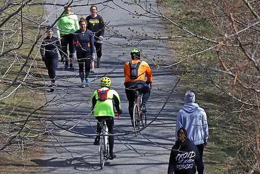 Walkers and bikers enjoy the Allegheny Heritage trail on a sunny afternoon on the Northside of Pittsburgh, Pa., Sunday, March 22, 2020. (AP Photo/Gene J. Puskar)