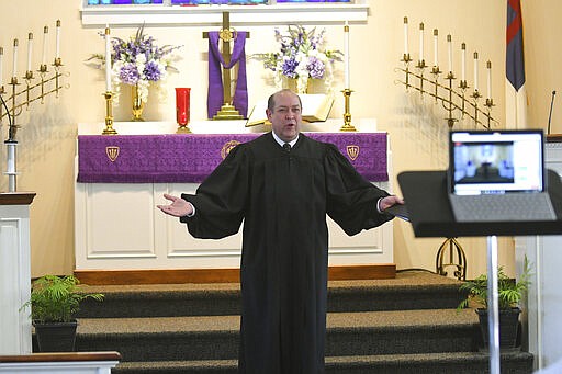 Pastor Ken McDowell conducts worship service while live streaming on Facebook at St. Paul's United Church of Christ Summer Hill in Auburn, Pa., on Sunday morning, March 22, 2020. Due to the coronavirus pandemic, there were no parishioners  in the church. They are asking people to join them for worship on their Facebook public page at Summer Hill UCC. (Jacqueline Dormer/The Republican-Herald via AP)