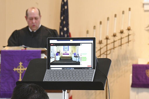 Pastor Ken McDowell conducts worship service while live streaming on Facebook at St. Paul's United Church of Christ Summer Hill in Auburn, Pa., on Sunday morning, March 22, 2020. Due to the coronavirus pandemic, there were no parishoners in the church. They are asking people to join them for worship on their Facebook public page at Summer Hill UCC. (Jacqueline Dormer/The Republican-Herald via AP)