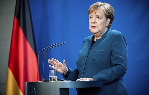 German Chancellor Angela Merkel speaks at a press conference about coronavirus, in Berlin, Sunday, March 22, 2020. German authorities have issued a ban on more than two people meeting outside of their homes, which they believe will be easier to follow than locking people in their homes. The vast majority of people recover from the new coronavirus. According to the World  Health Organization, most people recover in about two to six weeks, depending on the severity of the illness. (Michael Kappeler/Pool photo via AP)