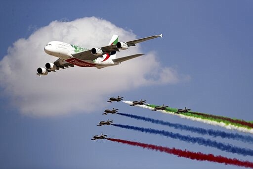 FILE - In this Nov. 17, 2019 file photo, an Emirates Airline A-380 leads the &quot;Al Fursan,&quot; or the Knights, UAE air force aerobatic display team during the opening day of the Dubai Airshow, in Dubai, United Arab Emirates. On Sunday, March 22, 2020, long-haul carrier Emirates said it would suspend all passenger flights beginning Wednesday, March 25, 2020, over the effects of the coronavirus pandemic. (AP Photo/Kamran Jebreili, File)