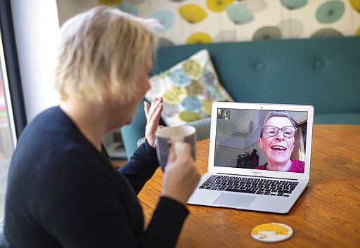 Helen Walters, left, talks to her mother Gillian using video calling, as people find alternative ways to celebrate Mother's Day to limit the potential spread of COVID-19 coronavirus, in London, Sunday March 22, 2020.  Sunday is Mother&#146;s Day in Britain and the government has a stark message for millions of citizens, that visiting your mom could kill her as for older adults and people with existing health problems, the virus can cause severe illness, including pneumonia. (Dominic Lipinski / PA via AP)