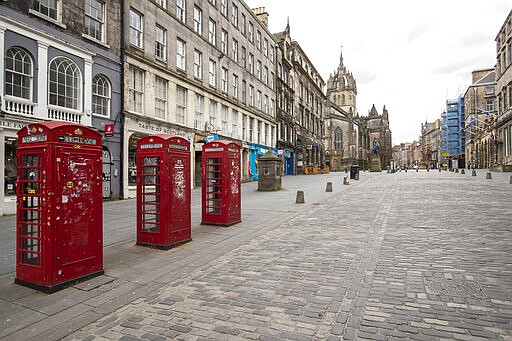 This photo shows the Royal Mile, part of the Old Town of Edinburgh, Scotland, Britain, Saturday, March 21, 2020, on the first day after Prime Minister Boris Johnson ordered pubs and restaurants across the country to close as the government announced measures to cover the wages of workers who would otherwise lose their jobs due to the coronavirus outbreak. (Jane Barlow/PA via AP)