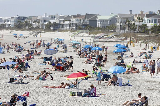 Despite warnings from government officials take caution and self distance because of coronavirus, beach goers enjoy the Isle of Palms beach, Friday, March 20, 2020, in Isle of Palms, S.C. City authorities are restricting access to the popular beach from 7 a.m. to 7 p.m. daily starting Saturday to help stop the spread of the coronavirus. (AP Photo/Mic Smith)