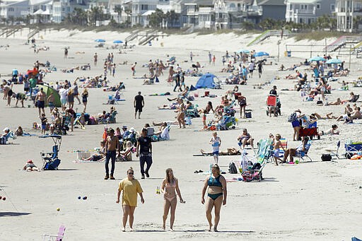 Despite warnings from government officials take caution and self distance because of coronavirus, beach goers enjoy the Isle of Palms beach, Friday, March 20, 2020, in Isle of Palms, S.C. City authorities are restricting access to the popular beach from 7 a.m. to 7 p.m. daily starting Saturday to help stop the spread of the coronavirus. (AP Photo/Mic Smith)