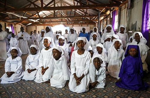 Young Christian faithful of the Legio Maria African Mission attend a Sunday mass service in the Kibera slum of the capital Nairobi, Kenya Sunday, March 22, 2020. In Kenya, the Ministry of Health has banned all public gatherings and meetings in order to limit the spread of the new coronavirus that causes COVID-19 but has permitted normal church services to continue so long as they provide hand sanitizing or washing facilities to attendees. (AP Photo/Brian Inganga)