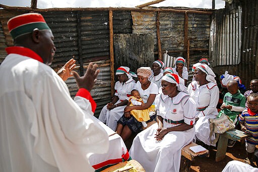 Christian faithful of the Africa Inland Church attend a Sunday mass service in the Kibera slum of the capital Nairobi, Kenya Sunday, March 22, 2020. In Kenya, the Ministry of Health has banned all public gatherings and meetings in order to limit the spread of the new coronavirus that causes COVID-19 but has permitted normal church services to continue so long as they provide hand sanitizing or washing facilities to attendees. (AP Photo/Brian Inganga)