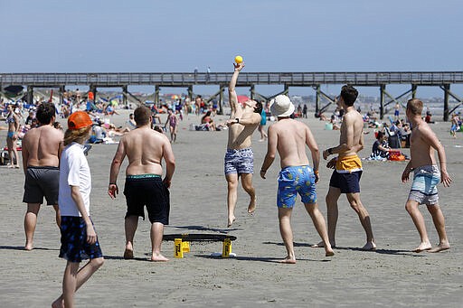 Despite warnings from government officials take caution and self distance because of coronavirus, beach goers enjoy the Isle of Palms beach, Friday, March 20, 2020, in Isle of Palms, S.C. City authorities are restricting access to the popular beach from 7 a.m. to 7 p.m. daily starting Saturday to help stop the spread of the coronavirus. (AP Photo/Mic Smith)