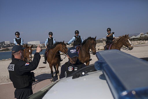 French police patrol a beach in Marseille, southern France, Thursday, March 19, 2020. French President Emmanuel Macron said that for 15 days people will be allowed to leave the place they live only for necessary activities such as shopping for food, going to work or taking a walk. For most people, the new coronavirus causes only mild or moderate symptoms. For some it can cause more severe illness, especially in older adults and people with existing health problems. (AP Photo/Daniel Cole)