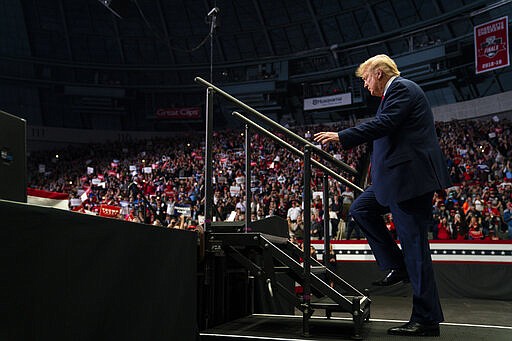 FILE - In this March 2, 2020, file photo President Donald Trump arrives to speak at a campaign rally at Bojangles Coliseum in Charlotte, N.C. For the next seven months, Trump may be consigned to campaigning in a country beset by a fear of job loss, bankruptcy and disease. It will require a remarkable pivot for the president, who has relentlessly cheered the stock market's rise and the economy's strength as the central predicate for a second term. (AP Photo/Evan Vucci, File)