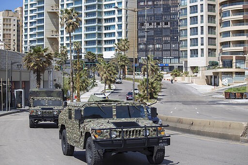 Lebanese army vehicles patrol the streets urging people to stay home unless they have to leave for an emergency in an effort to prevent the spread of coronavirus, in Beirut, Lebanon, Sunday, March 22, 2020. (AP Photo/Hassan Ammar)